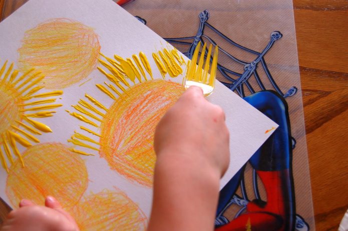Ребёнок рисует лучи солнышка вилкой