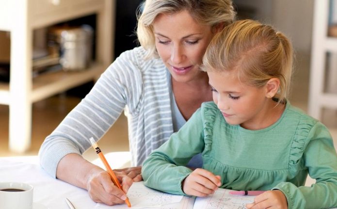 Мама помогает дочери выполнять уроки